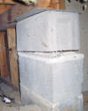 Concrete crawl space support posts in Charles City that are showing signs of failure as they sink into the earth.