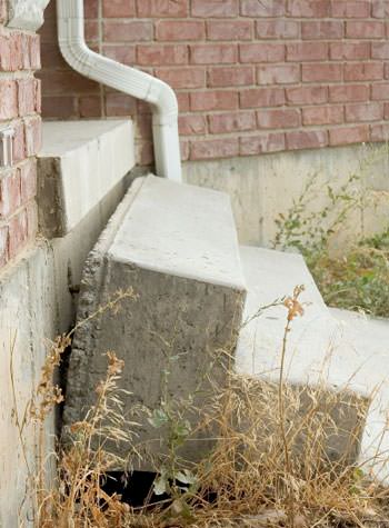 sinking outdoor concrete steps showing cracking and soil washout in Creston