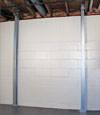 A steel i-beam system installed on a Adel foundation wall