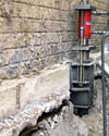 A completed installation of foundation push piers lifting a foundation in Webster City