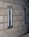 an inside view of foundation wall anchors installed along a basement wall to brace and repair the structure in Boone